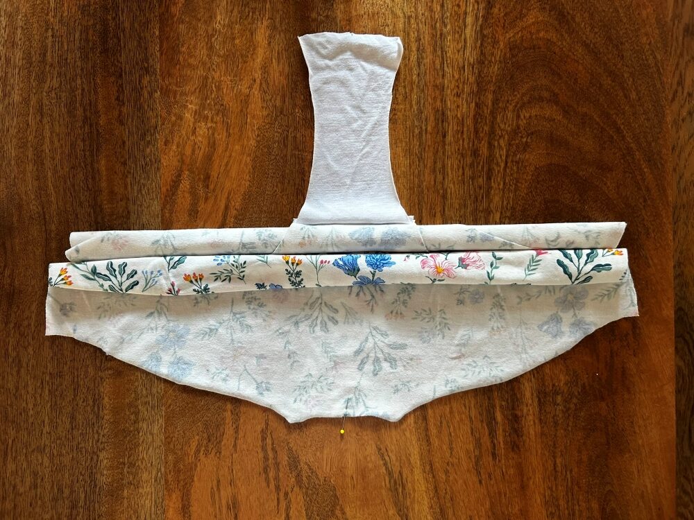 Back fabric piece rolled up and positioned next to the rolled up front piece.