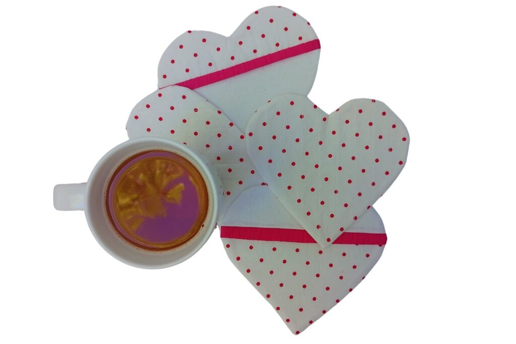 Four heart-shaped coasters and a mug of tea, all from a top view