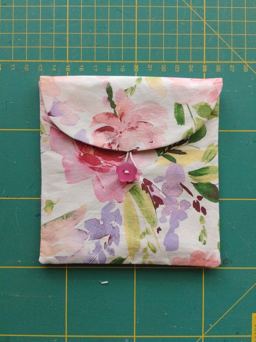 Closed sanitary pad pouch, with elastic loop fastened around the button.