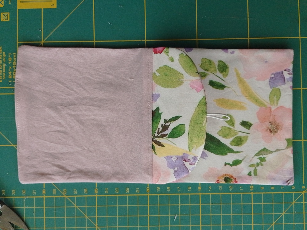 Pouch turned right side out showing the floral flap and pink lining.