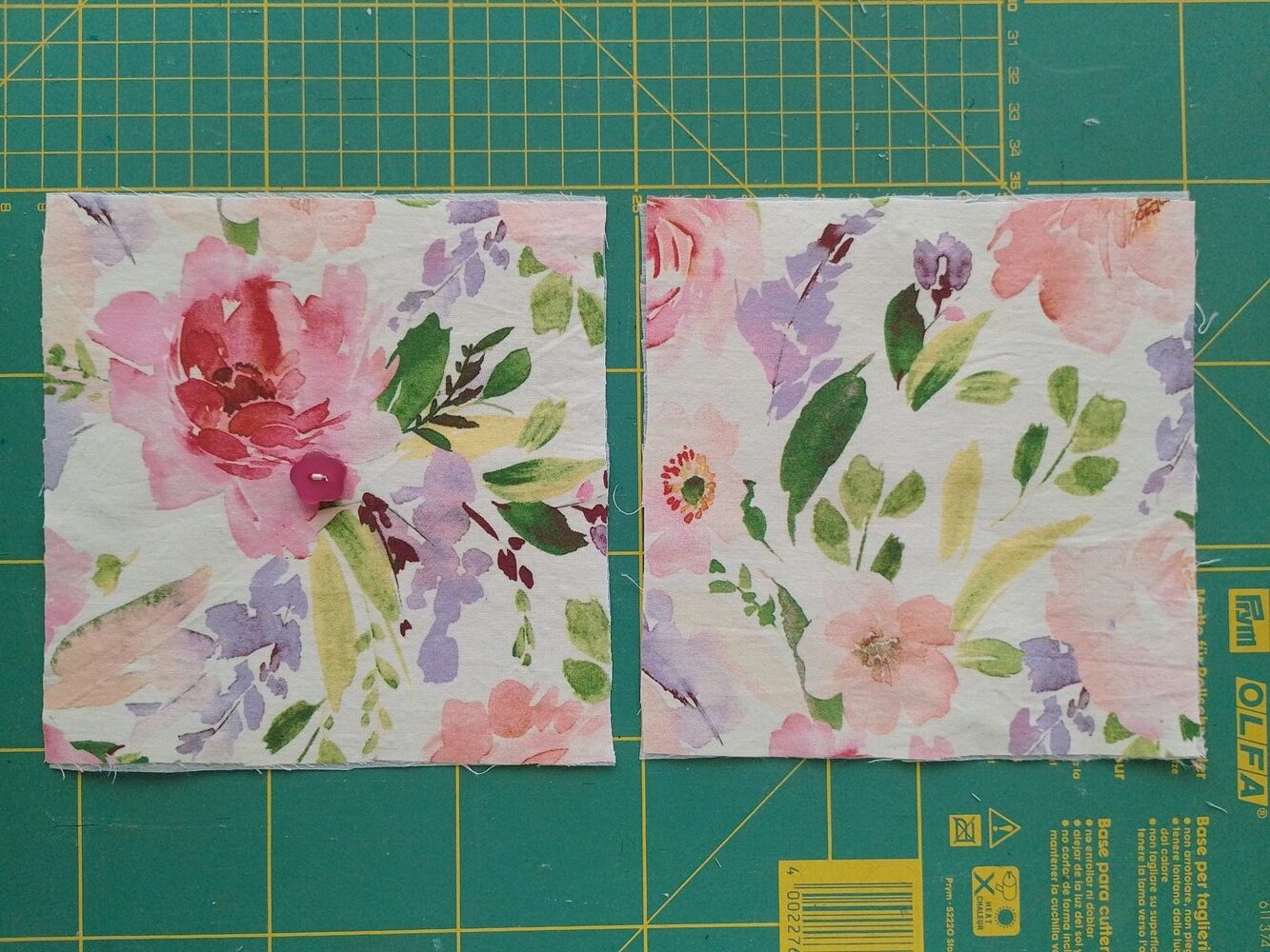 Two square fabric pieces with floral prints, one with a button sewn in the center.