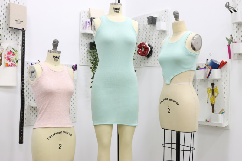 Three rib knit tank tops and dresses displayed on dress forms in a sewing studio, including cropped, full-length tank, and tank dress versions.