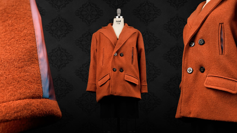 A collage showing a rust-orange, double-breasted peacoat on a mannequin, with close-up views of the button details and the colorful lining.