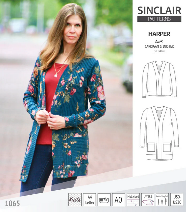 A woman wearing a hip-length, open-front cardigan made from a teal floral ribbed-knit fabric.