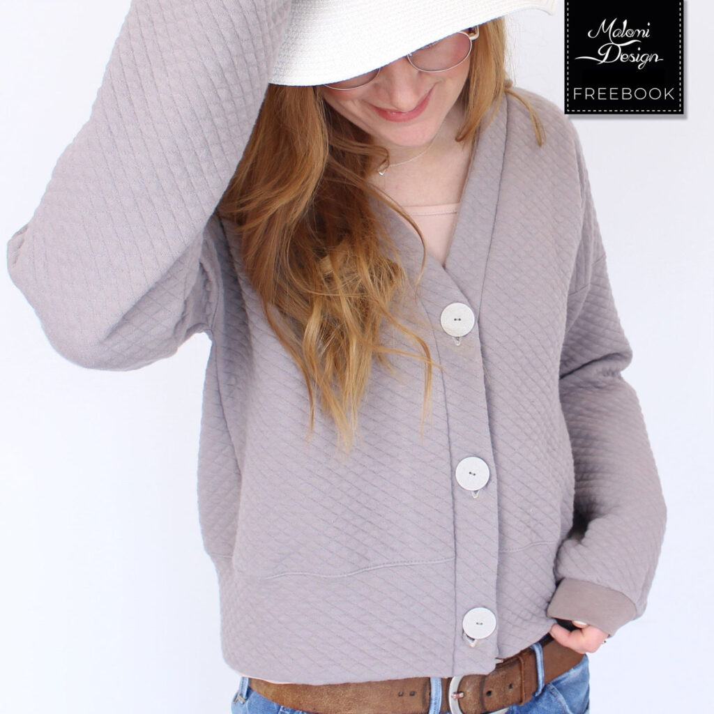 A woman wearing a boxy, button-front cardigan made from a dusty pink quilted fabric.