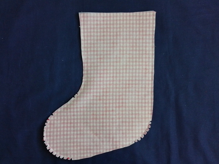 sewed stocking shape made of red and white gingham, with the curved seam allowance snipped and notched at the curves.