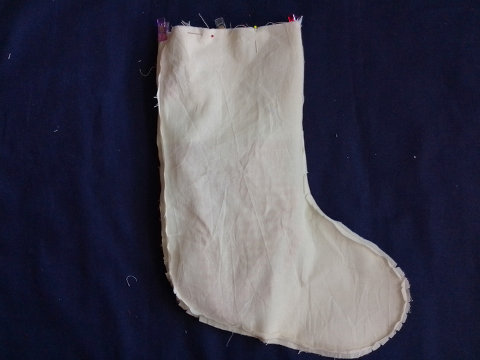 The main stocking assembly fully inserted into the calico lining, with the top raw edges aligned and secured with pins and clips.