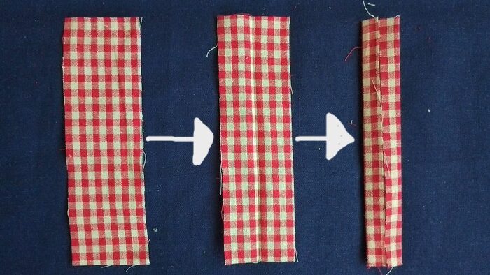 Three vertical strips of red and white gingham fabric, showing progressive folds. The rightmost strip is fully folded into a narrow strap.