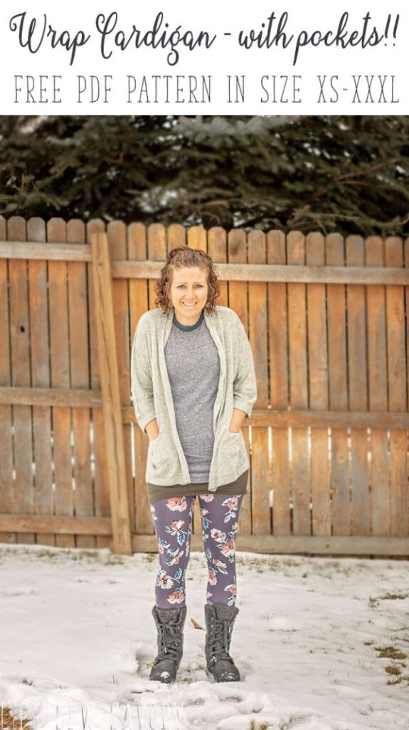 A woman standing in the snow, wearing a light gray open-front cardigan with large pockets over leggings and boots.