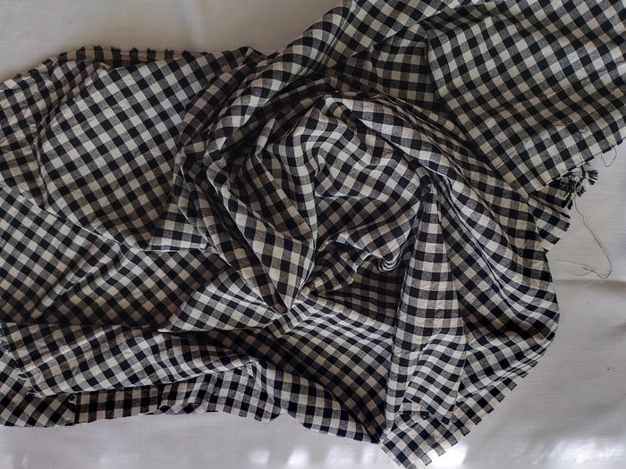 black and white gingham checked fabric draped in a loose swirl.