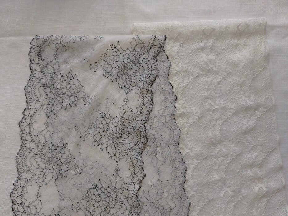 Two strips of floral lace fabric side-by-side; the left piece is white with fine black outlining, and the right piece is solid white.