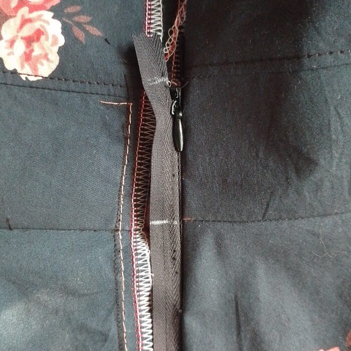The invisible zipper zipped closed, showing white chalk marks drawn across the zipper tape.