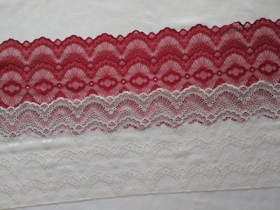 Horizontal strips of scalloped stretch lace; the top strip is deep red and the bottom strips are white.