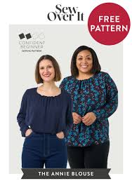 Two women modeling a loose, long-sleeved blouse with a gathered neckline. The woman on the left wears a solid navy version, and the woman on the right wears a dark floral print version.