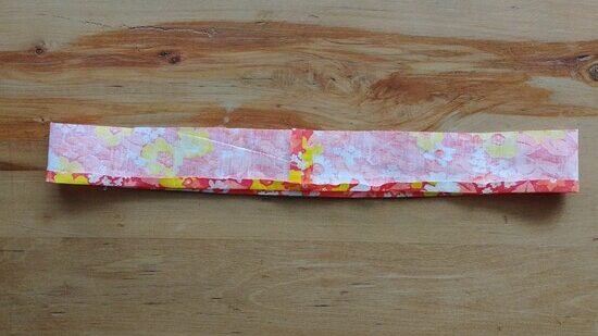 a loop of fabric with the seam allowance in the center pressed open and the bottom edge pressed onto the wrong side of the fabric loop