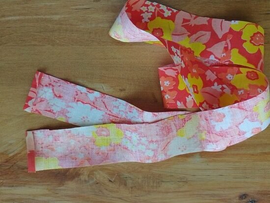 A folded floral fabric strip with two short edges folded.