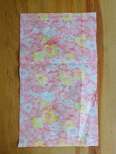 A rectangular piece of floral fabric laid flat with a crease near the middle.