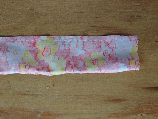 A narrow floral fabric strip sewn together and laid flat, wrong side facing up.