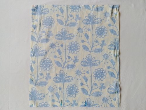 Two blue and off-white fabric pieces, wrong side out, pinned together