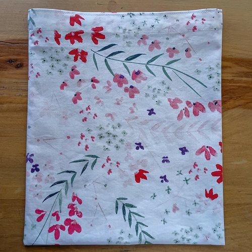 A floral fabric bag turned right side out and laid flat.