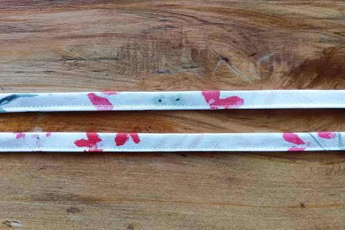 Two long, thin pieces of floral fabric sewn closed to make a drawstrings.