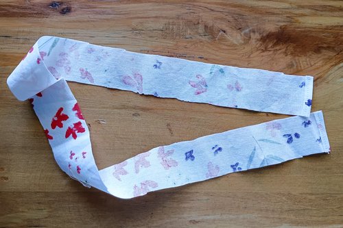 A long, thin strip of the floral fabric with its short ends folded over and sewn down.