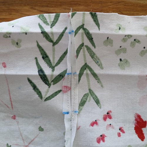 A close-up of the same pressed-open vertical seam, but the top corners of the seam allowance have been trimmed off at an angle.