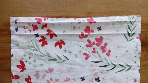 The floral fabric with a folded top, showing a sewn line of stitching straight down both the left and right side edges.