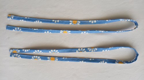 Two matching finished fabric straps laid side by side.
