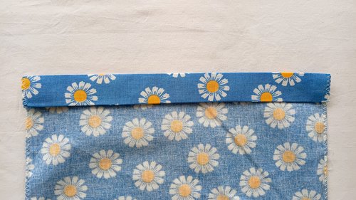 A strip of blue floral fabric folded over twice onto the wrong side of fabric