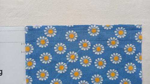 A blue floral fabric with two parallel horizontal lines drawn across a top section.