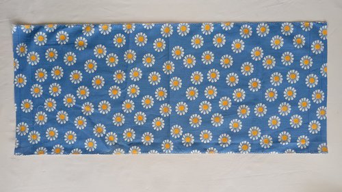 A side seam of a blue floral bag with both raw edges finished using a zigzag stitch.