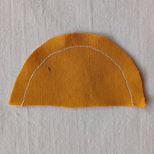 Semi circle of yellow fabric with a line of stitching