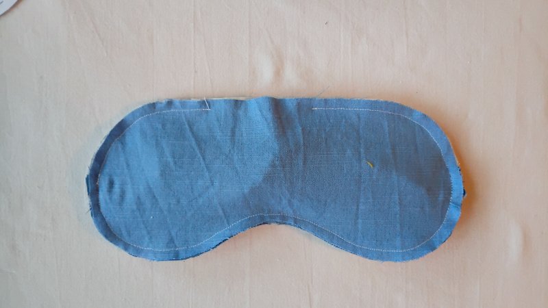Sleep mask sewn together with a small gap left unstitched at the top.