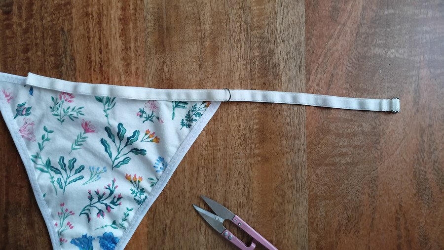 elastic strap threaded into ring on front piece of g-string pattern