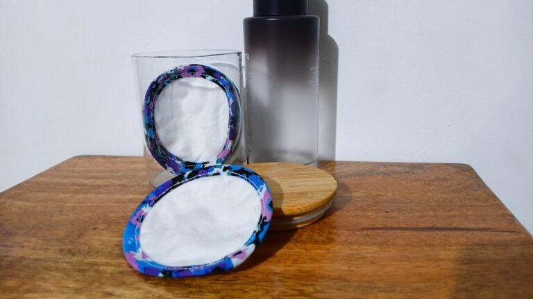 Two finished flannel rounds edged with floral bias tape, one standing in a glass jar and one resting on a wooden table
